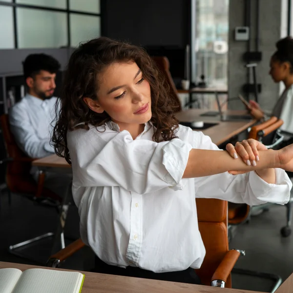 Une femme étire son bras, symbolisant la flexibilité et le bien-être dans un contexte d'abonnement corporatif.