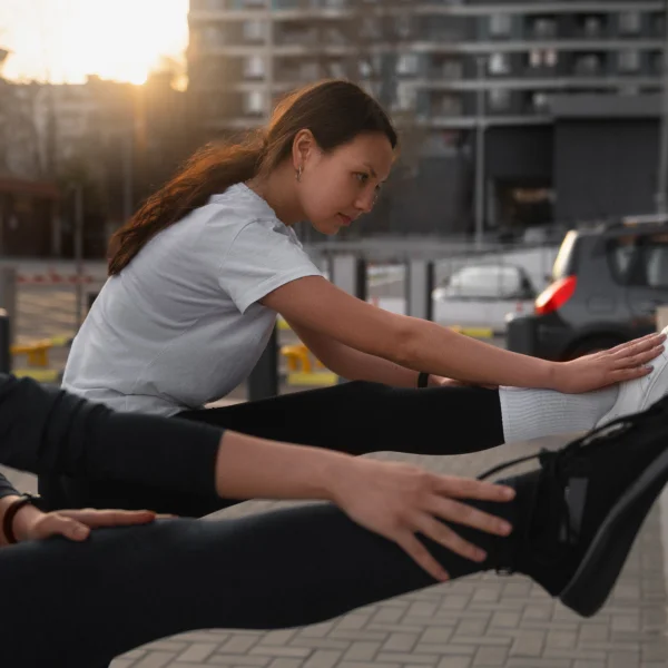Deux femmes s'étirent sur la rue, participant à une séance de coaching privé.